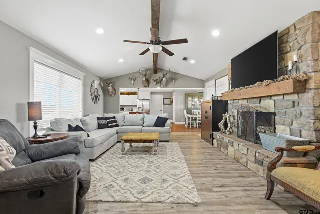 a living room with furniture a flat screen tv and a fireplace