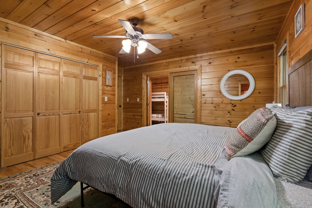 220 Solar Drive Blue Ridge, GA 30513 - Photo 20 of 59 a spacious bedroom with a bed and a chandelier