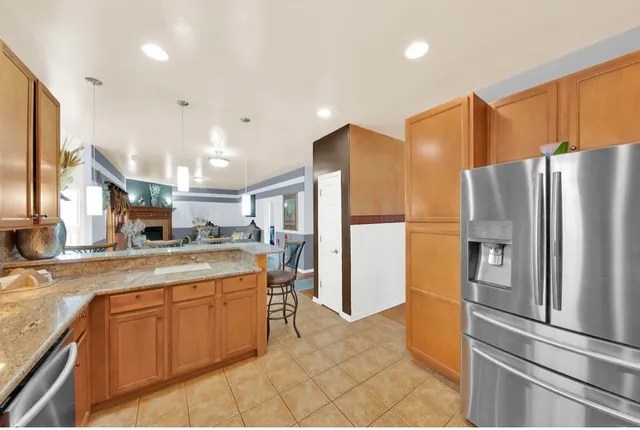 a kitchen with stainless steel appliances granite countertop a refrigerator and a sink