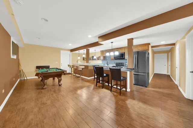 a living room with furniture a table and kitchen view