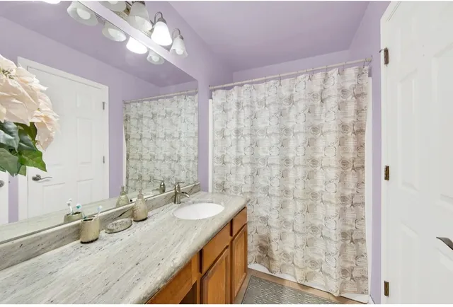 a bathroom with a granite countertop sink a mirror and a shower