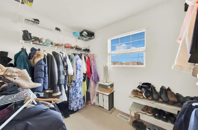 a view of walk in closet with clothes and shoes