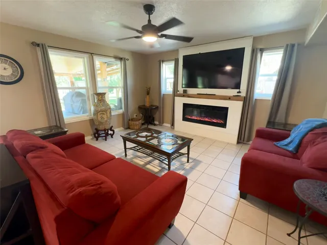 a living room with furniture a fireplace and a flat screen tv