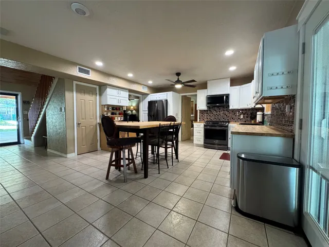 a kitchen with stainless steel appliances granite countertop a refrigerator and a sink