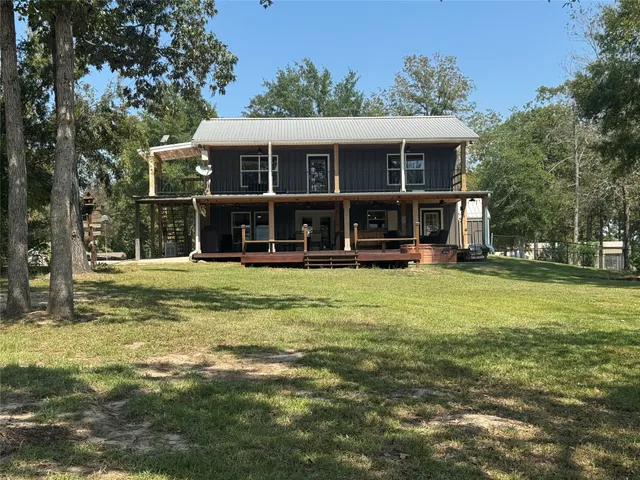 a view of house with backyard and trees