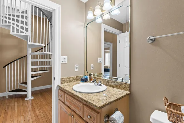 a bathroom with a granite countertop sink a mirror and a toilet