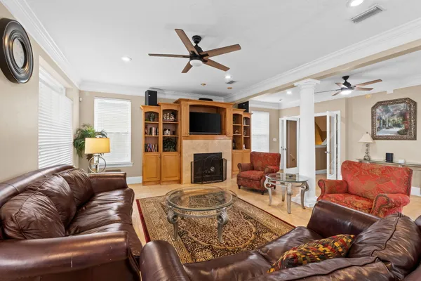 a living room with furniture a fireplace and a ceiling fan