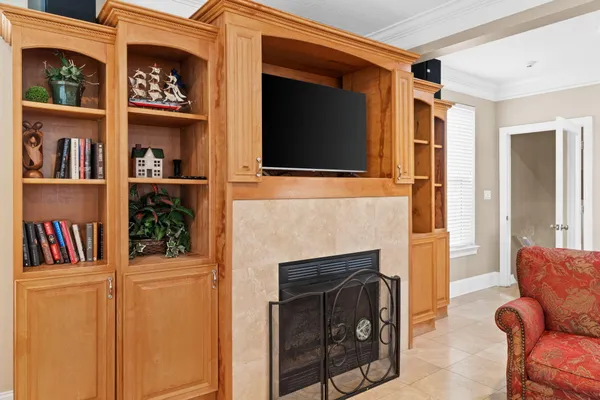 a living room with fireplace furniture and a view of kitchen