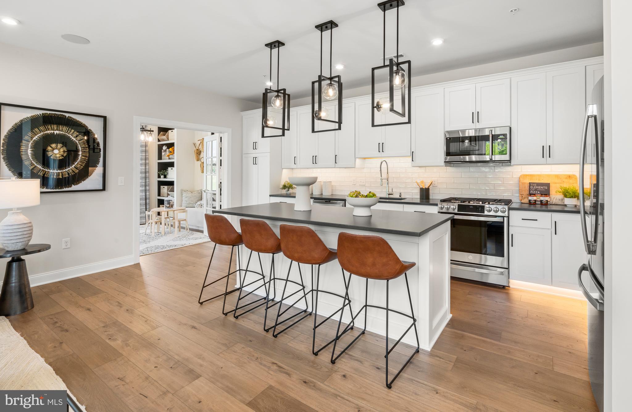 18 Baldwin Way Sellersville, PA 18960 - Photo 2 of 21 a kitchen with stainless steel appliances granite countertop a kitchen island a stove a table and chairs