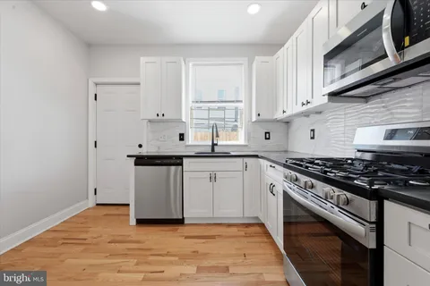 a kitchen with granite countertop a stove sink and cabinets
