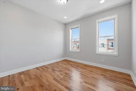 a view of empty room with wooden floor
