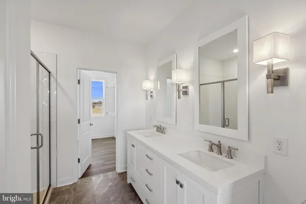 a bathroom with a double vanity sink mirror and shower