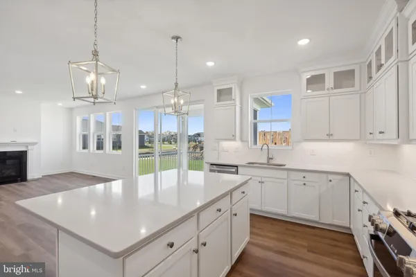 a large kitchen with kitchen island a large counter space a sink stainless steel appliances and cabinets