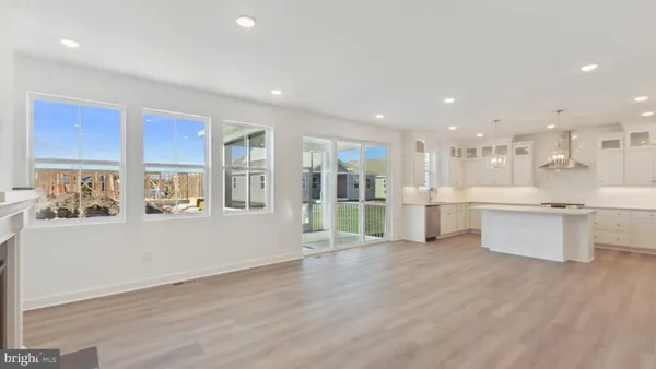 a view of a kitchen with a sink wooden cabinets and glass windows