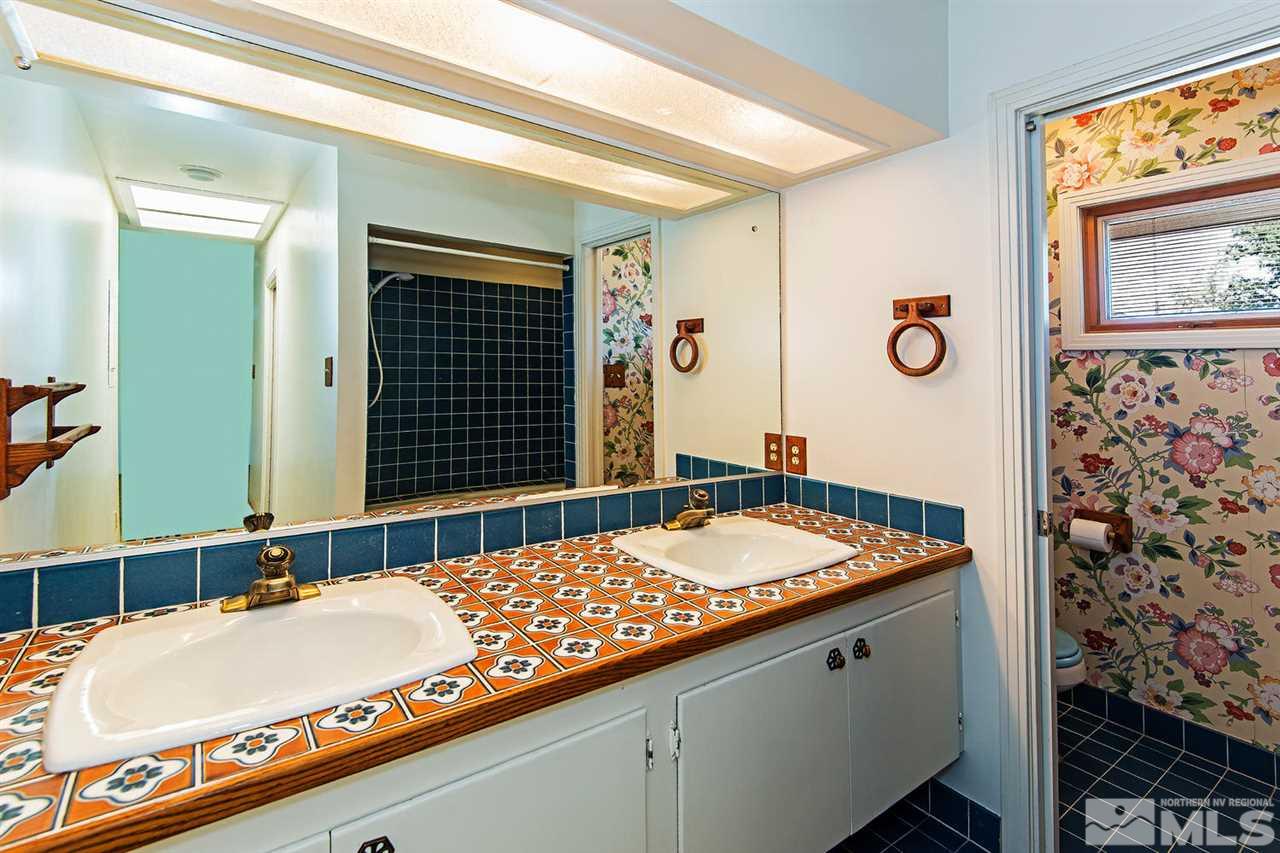 610 Robin Street Reno, NV 89509 - Photo 15 of 23 a bathroom with a granite countertop sink and a mirror