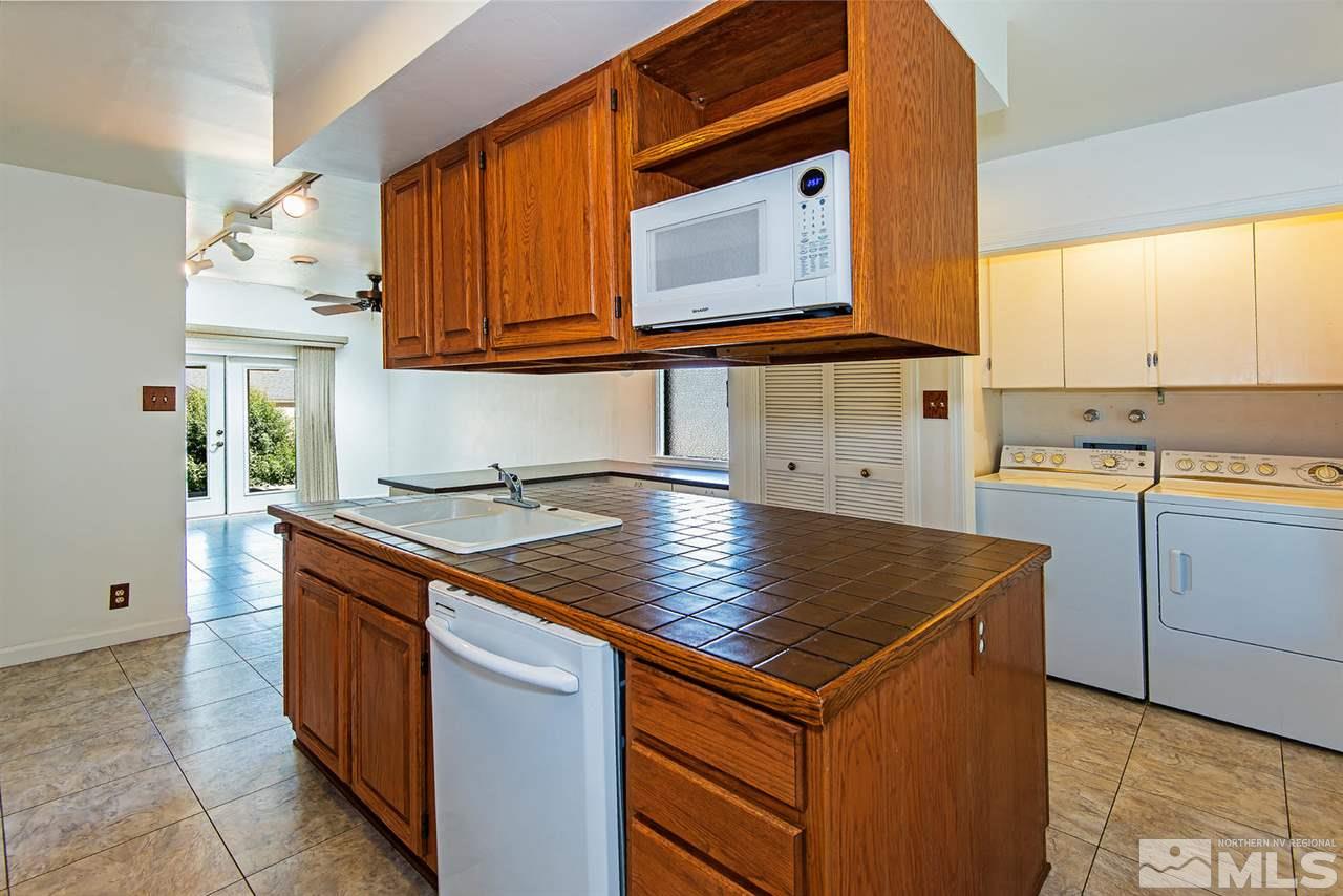 610 Robin Street Reno, NV 89509 - Photo 9 of 23 a kitchen with stainless steel appliances granite countertop a sink and a stove