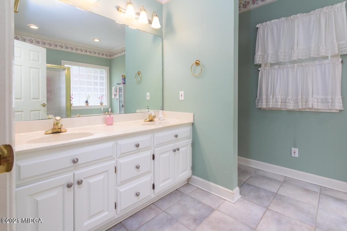 7471 Rivoli Road Macon, GA 31210 - Photo 14 of 26 a bathroom with a double vanity sink and a mirror