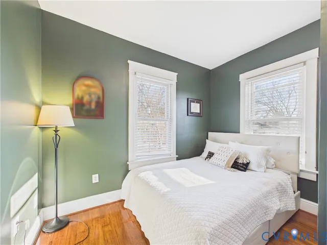 a bedroom with a bed and a painting on the wall