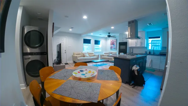 a dining room with furniture a fireplace a rug and kitchen view