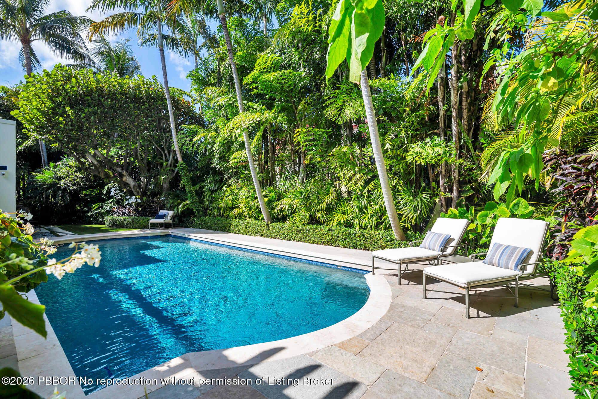 111 Seagate Road Palm Beach, FL 33480 - Photo 26 of 35 a view of a swimming pool with lawn chairs under an umbrella
