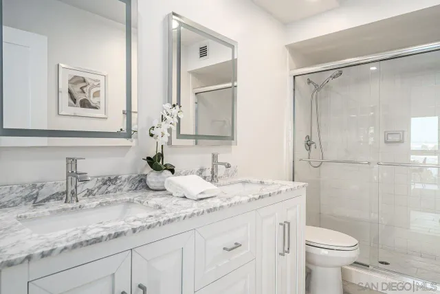 a bathroom with a granite countertop sink a toilet and a mirror