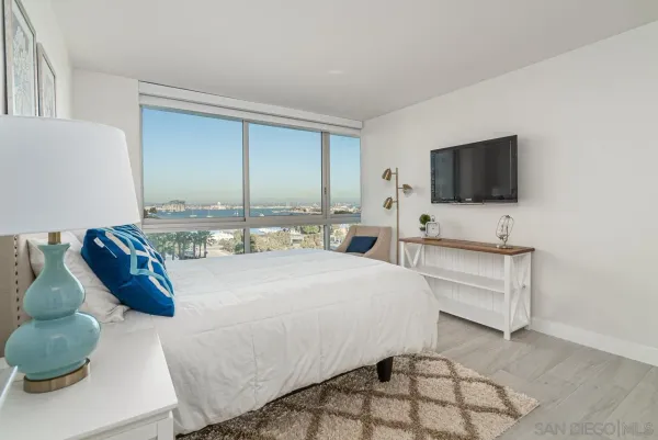a spacious bedroom with a bed and a flat screen tv