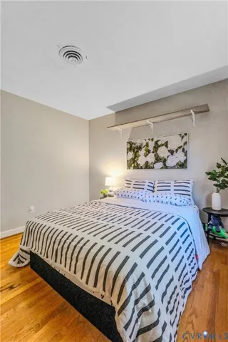 a bedroom with a bed and wooden floor