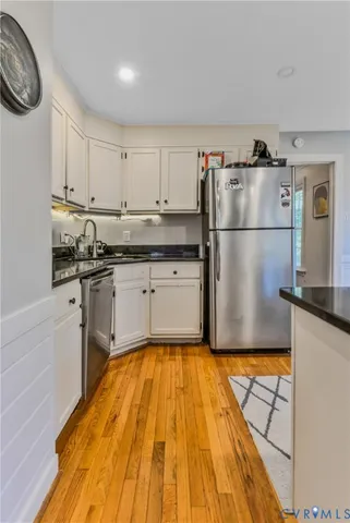 a kitchen with kitchen island a sink a stove and white cabinets