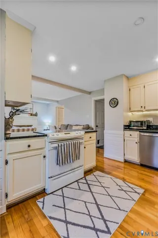 a kitchen with granite countertop a stove a sink and a refrigerator