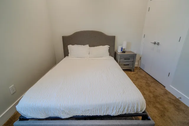a large bed sitting in a bedroom next to a window