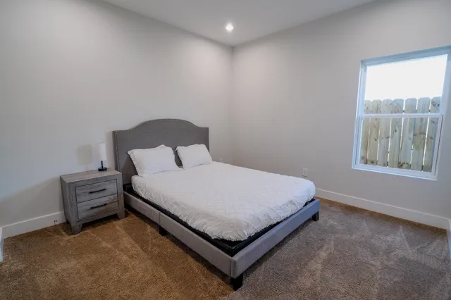 a bed sitting in a bedroom next to a window