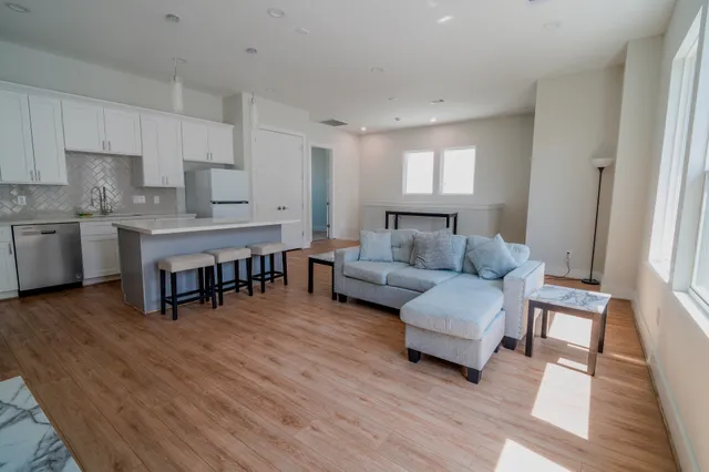 a living room with furniture and a wooden floor