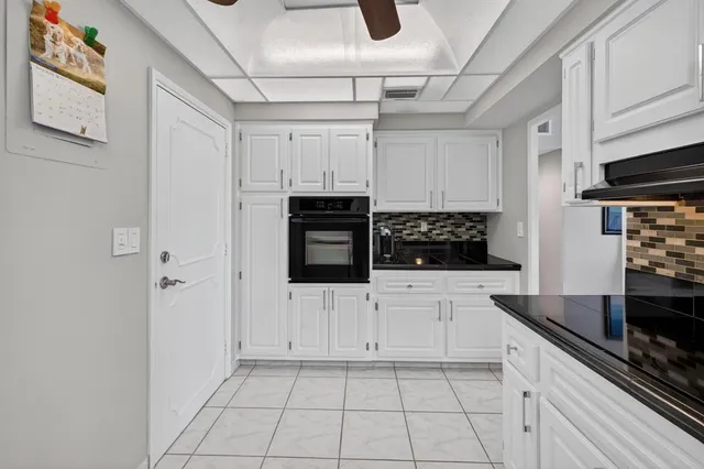 a kitchen with white cabinets and appliances