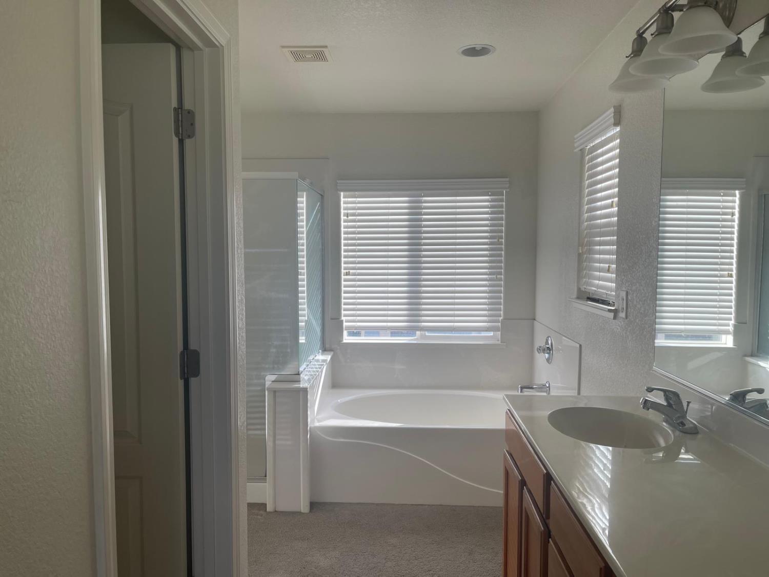 1006 Papaya Street Madera, CA 93638 - Photo 11 of 17 a bathroom with a tub sink and mirror