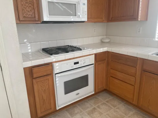 a kitchen with granite countertop white cabinets and white appliances