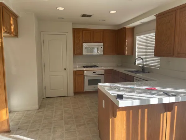 a kitchen that has a sink a stove and a refrigerator