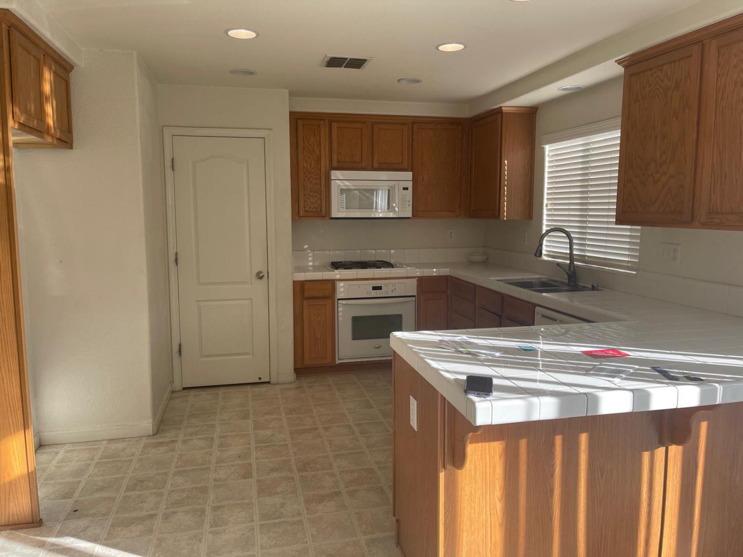 1006 Papaya Street Madera, CA 93638 - Photo 5 of 17 a kitchen that has a sink a stove and a refrigerator