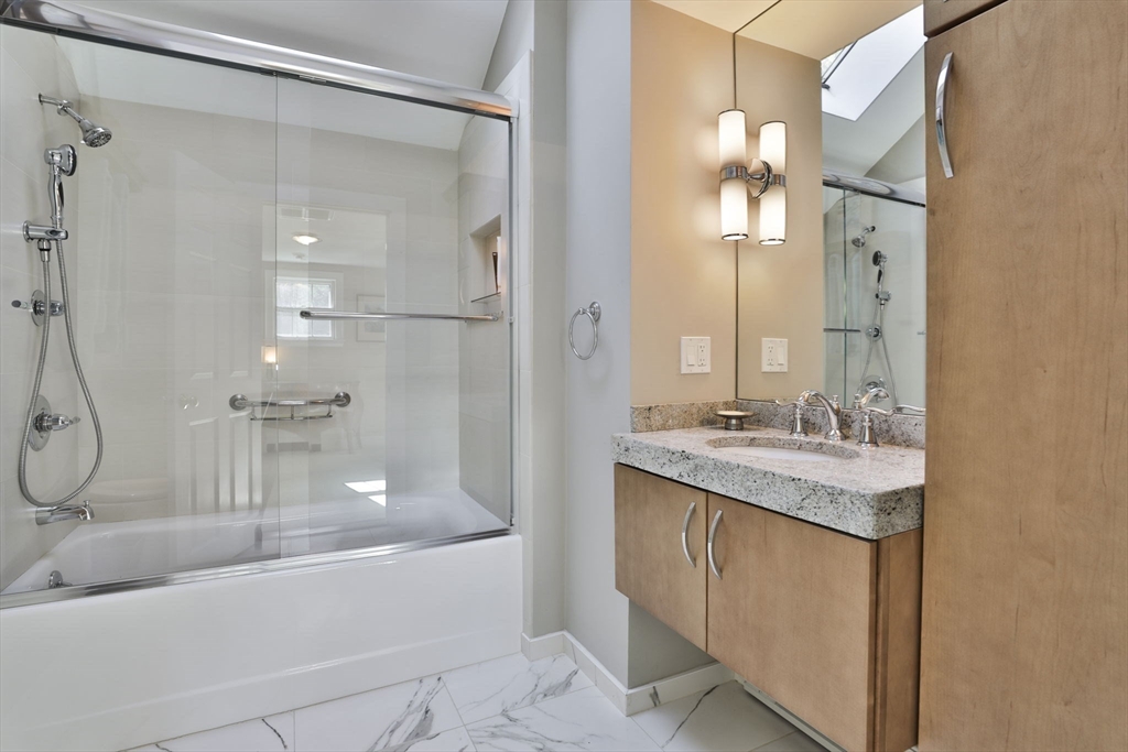 32 Columbine Road Milton, MA 02186 - Photo 32 of 40 a bathroom with a granite countertop sink mirror and a bathtub