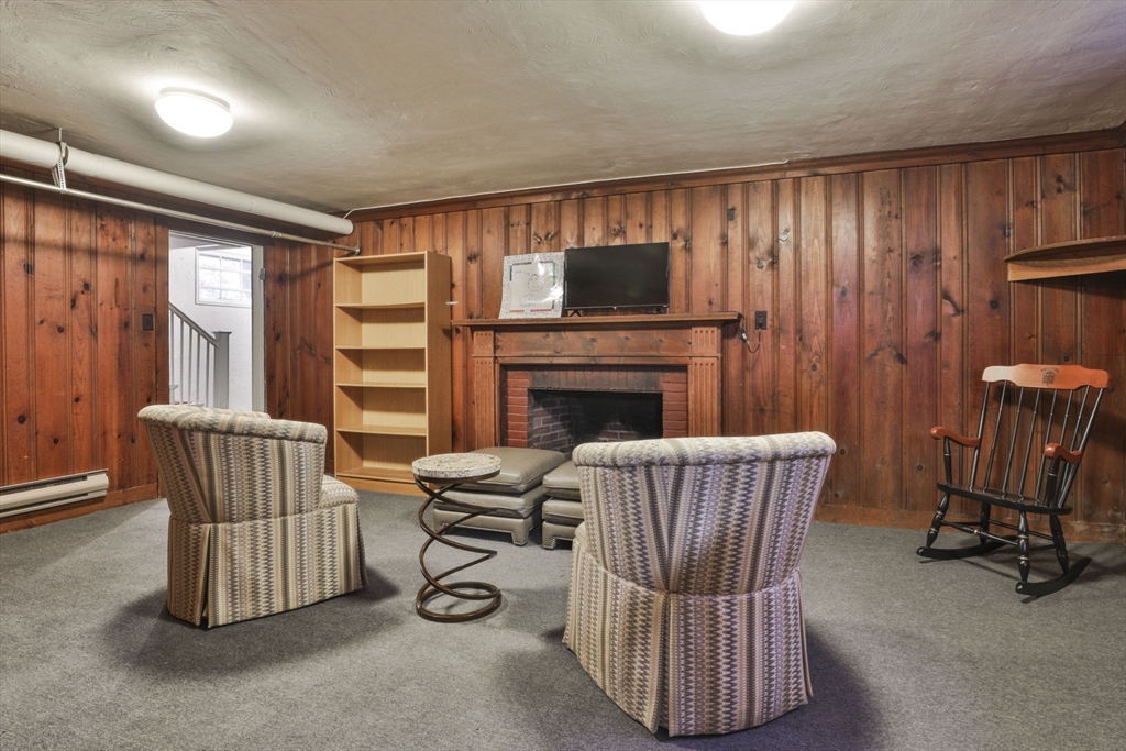32 Columbine Road Milton, MA 02186 - Photo 34 of 40 a living room with furniture a flat screen tv and a fireplace