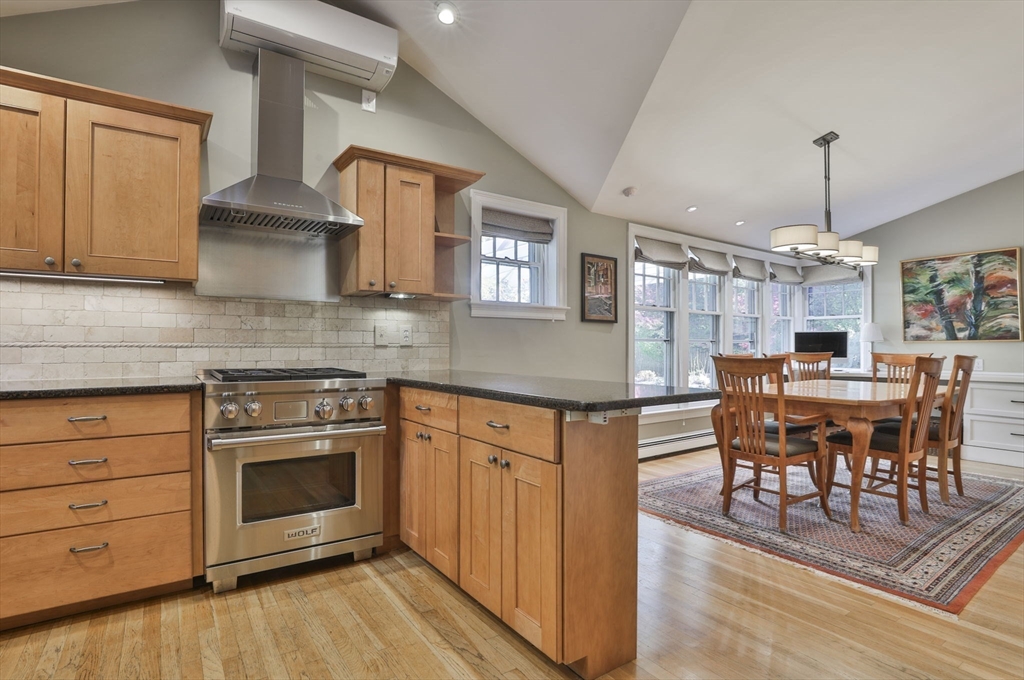 32 Columbine Road Milton, MA 02186 - Photo 10 of 40 a kitchen with stainless steel appliances granite countertop a stove top oven a sink dishwasher a dining table and chairs with wooden floor