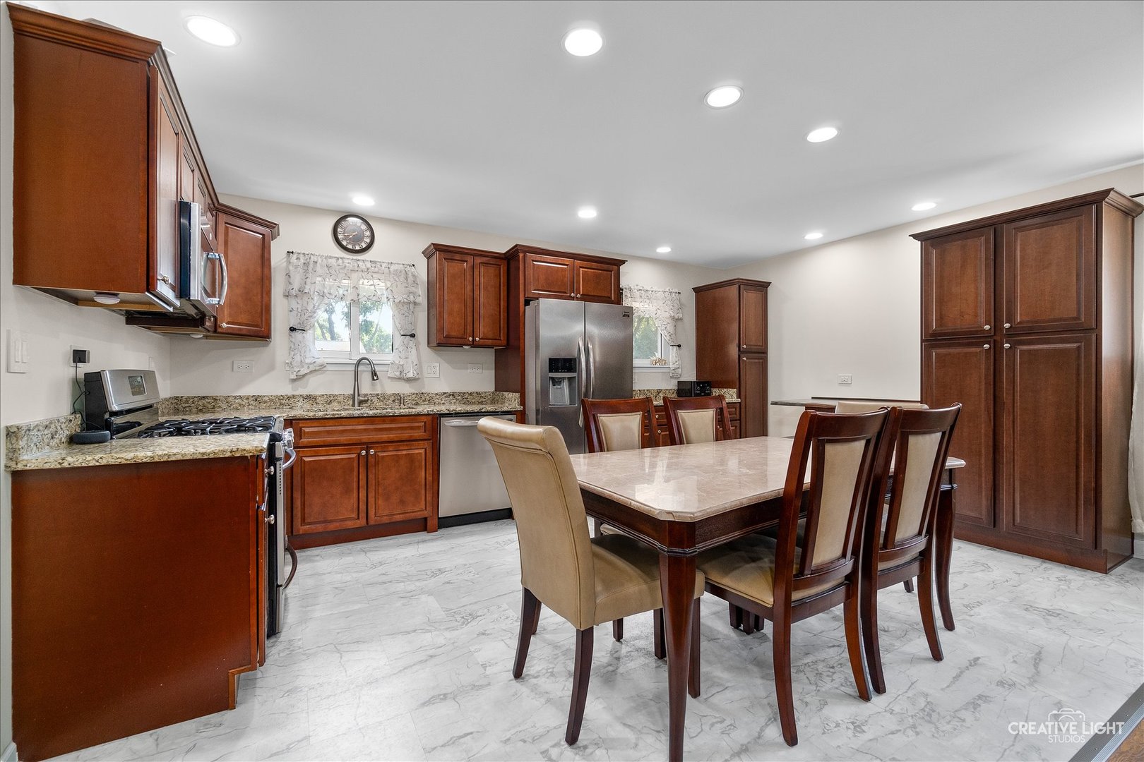129 Oxford Road Bolingbrook, IL 60440 - Photo 4 of 23 a kitchen with stainless steel appliances granite countertop a table chairs sink refrigerator and cabinets