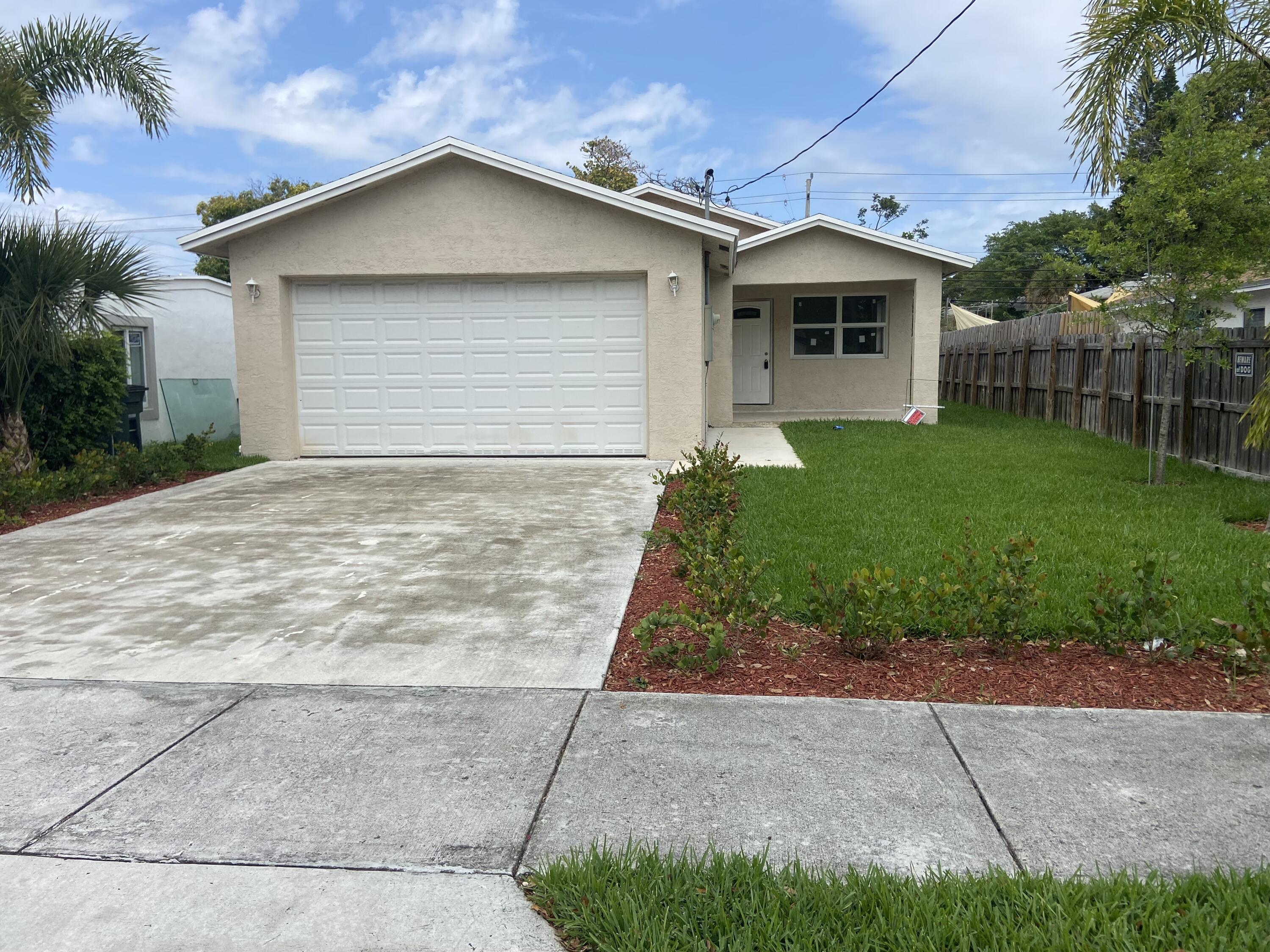 171 Northeast 15th Terrace Boca Raton, FL 33431 - Photo 1 of 2 a front view of a house with a yard and garage
