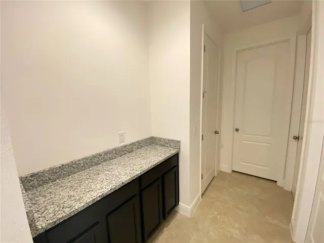 a spacious bathroom with a granite countertop double vanity sink a mirror and a shower