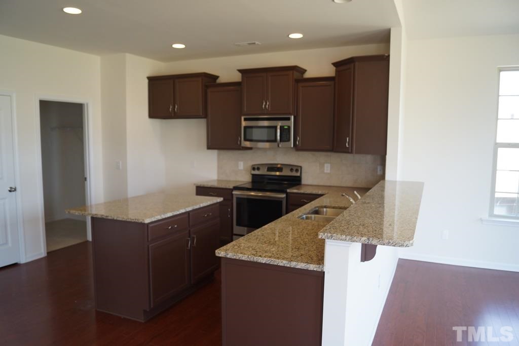 2740 Shepherd Valley Street Raleigh, NC 27610 - Photo 11 of 15 a kitchen with stainless steel appliances granite countertop a refrigerator sink and microwave