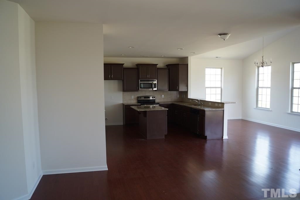 2740 Shepherd Valley Street Raleigh, NC 27610 - Photo 12 of 15 a kitchen with granite countertop a stove and a refrigerator