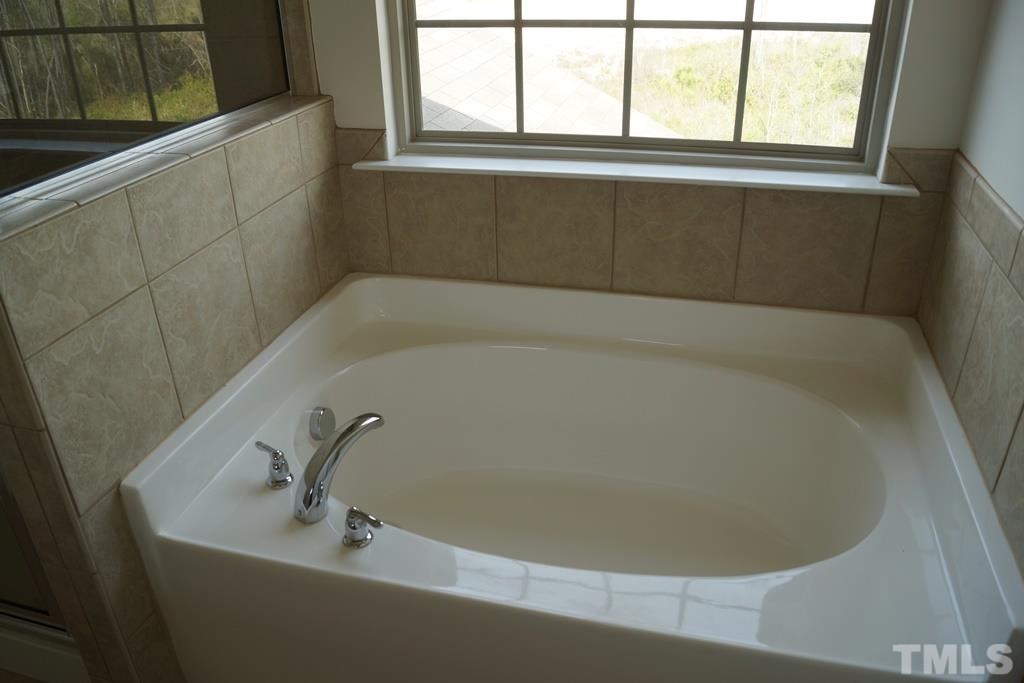 2740 Shepherd Valley Street Raleigh, NC 27610 - Photo 13 of 15 a white bath tub sitting in a bathroom next to a window