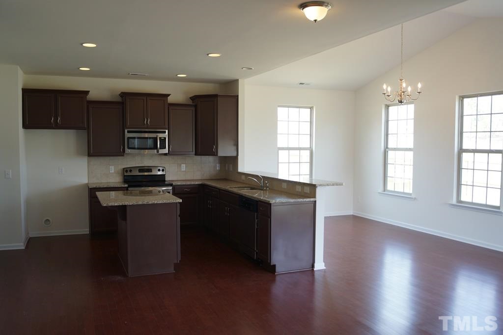 2740 Shepherd Valley Street Raleigh, NC 27610 - Photo 4 of 15 a kitchen with stainless steel appliances granite countertop a stove a sink a refrigerator and a microwave