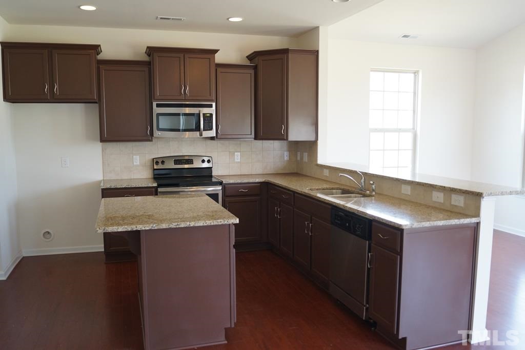 2740 Shepherd Valley Street Raleigh, NC 27610 - Photo 5 of 15 a kitchen with stainless steel appliances granite countertop a sink stove and refrigerator