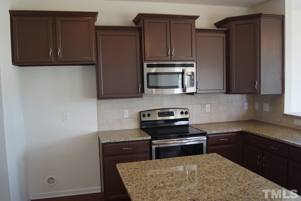 2740 Shepherd Valley Street Raleigh, NC 27610 - Photo 6 of 15 a kitchen with wooden cabinets and a stove top oven