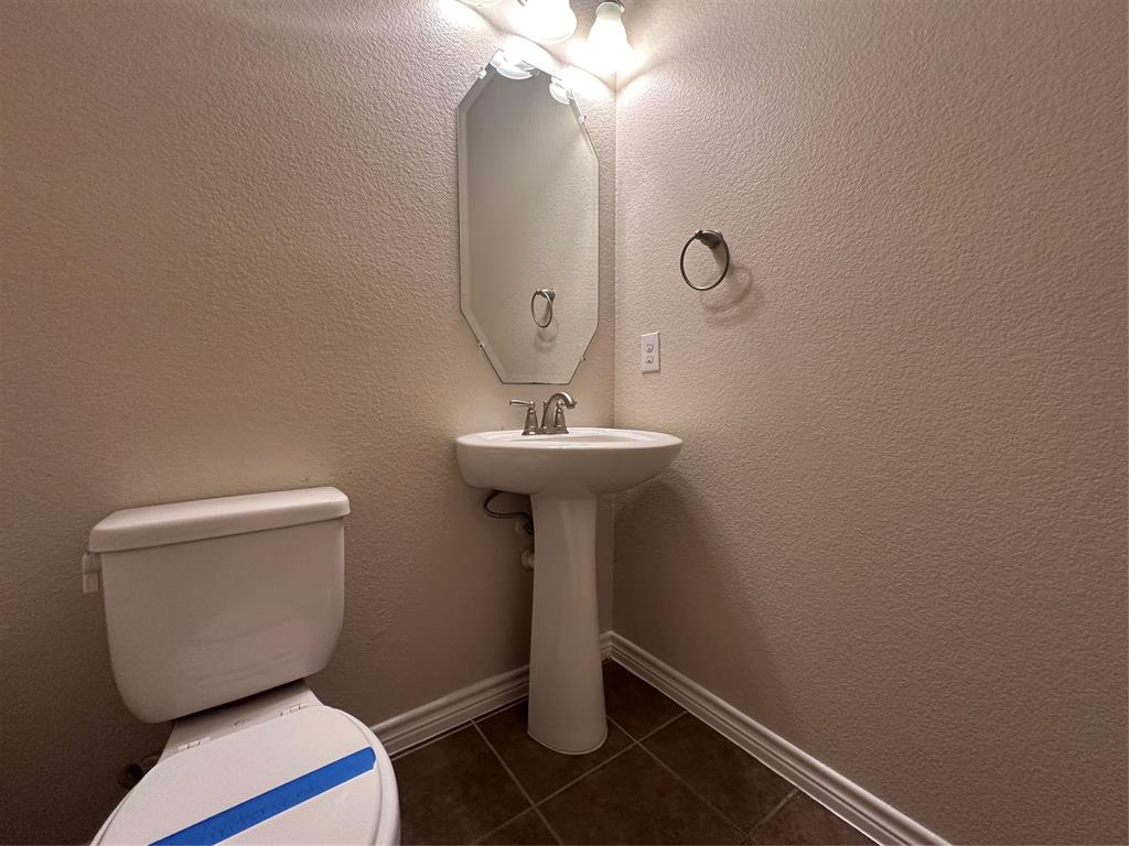 6549 Compass Ridge Drive Dallas, TX 75249 - Photo 12 of 19 a bathroom with a toilet sink and mirror